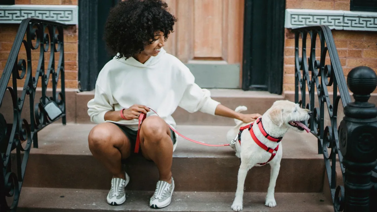Opiekunka siedzi z psem na schodach